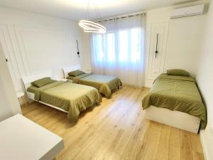 two beds in a room with wooden floors at Luxury apartment Podgorica in Podgorica