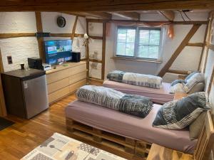 LeunaにあるPension 10 Bettenのベッド3台、薄型テレビが備わる客室です。