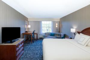 a hotel room with a bed and a flat screen tv at Courtyard Chapel Hill in Chapel Hill +39 photos