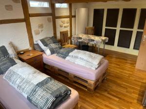 LeunaにあるPension 10 Bettenの木製の床と窓のある部屋にベッドが2つあります