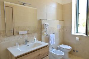 a bathroom with a sink and a toilet and a mirror at Villa Melina Bed & Breakfast in Agropoli