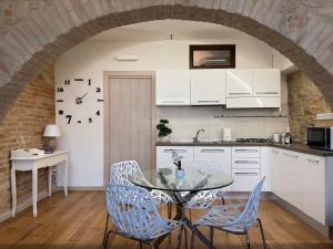 a kitchen with a glass table and chairs at La Cripta - a due passi dalla Basilica - ItalyWeGo in Santa Maria degli Angeli