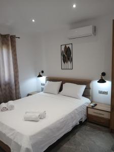 a bedroom with a large white bed with two towels on it at Διαμέρισμα με θέα in Agios Ioannis Kaspaka