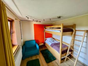a room with two bunk beds and a chair at Prywatne jezioro, SeliRaj GospAgro Alpaki,dwa pokoje-niezależnie wejście in Dzierzążno
