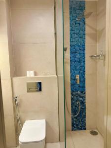 a bathroom with a toilet and a glass shower at Avyanna Gulhi Beach Hotel in Gulhi