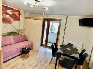 a living room with a pink couch and a table at Prywatne jezioro, SeliRaj GospAgro Alpaki,dwa pokoje-niezależnie wejście in Dzierzążno