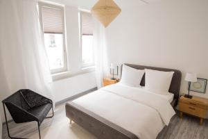 1 dormitorio blanco con 1 cama y 1 silla en Altstadt Suite en Weimar