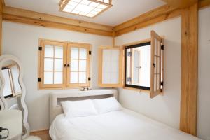 a bedroom with a bed and two windows at Insarang in Seoul