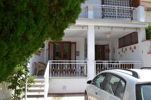 een wit huis met een auto ervoor geparkeerd bij Villa Eugenia - Mondello Beach in Palermo