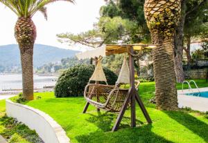 a park with a bench and a table and palm trees at Villa Büyükada I Private Pier & Seawater Pool in Istanbul