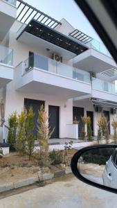 Una vista de una casa desde el espejo retrovisor de un coche. en Ariadne Complex Apartment 05 by Horizon Homes, en Ofrinion