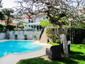 イスタンブールにあるVilla Büyükadaのスイミングプール付きの家の前の木