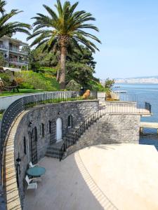 イスタンブールにあるVilla Büyükadaの水辺の横にテーブルと椅子が置かれたレンガの壁