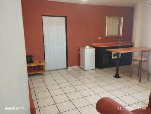 a kitchen with a white refrigerator and a table at Hotel Hacienda Nainari in Ciudad Obregón
