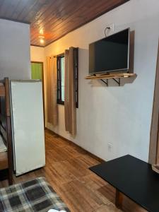 a living room with a flat screen tv on the wall at Pousada & Hostel Bicho Preguiça in Trindade +90 photos