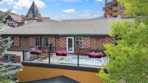 a house with a balcony with flowers on it at Lift House Lodge, Remodeled Downtown Lionshead Studio Condo in Vail
