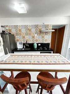 a kitchen with a table and two chairs at Recanto Salgando a Alma in Ubatuba