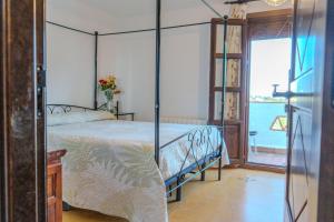 a bedroom with a canopy bed and a balcony at La Luna del sur B&B in Granada