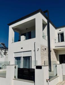 a white house with a black at Villa & Apartament Armonia 3 Gaia Flora GRECJA KRETA in Vamos