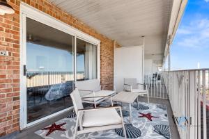 a balcony with chairs and tables and a large window at 2 Bed1 Bath on the Boardwalk by the Inlet in Ocean City