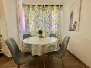 a dining room with a table and chairs and a window at Apartamento Centroplaya in Bueu +18 photos
