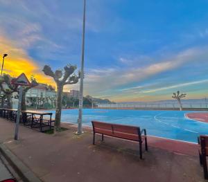 a park bench in front of a swimming pool at Apartamento Centroplaya in Bueu