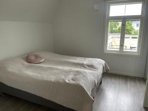 ein Bett in einem weißen Zimmer mit einem Fenster in der Unterkunft Havsnära stadspärla i Mariehamn in Mariehamn