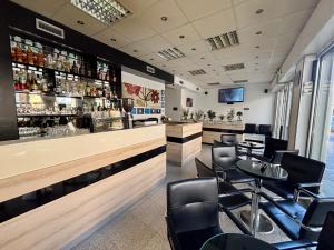 eine Bar in einem Restaurant mit Stühlen und einem Tisch in der Unterkunft Garni Hotel Consul in Niš