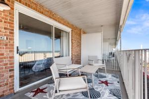 a balcony with chairs and tables and a large window at 2 Bed1 Bath on the Boardwalk by the Inlet in Ocean City
