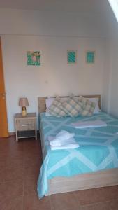 a bedroom with a bed with a blue comforter at Felicity - Geography of Bliss - 2BR Apartment with Unobstructed Sea View and Pool in Paralimni - 5 Min Kapparis Beach Drive in Paralimni
