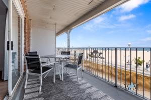 a balcony with a table and chairs and the ocean at 2 Bed1 Bath on the Boardwalk by the Inlet in Ocean City