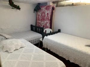 萨兰托Un Café en el camino Guest House的一间卧室配有两张床和椅子 更多22张照片