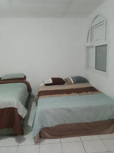 科万Cobán room的白色墙壁客房的两张床