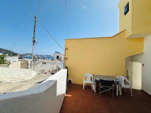 a balcony with a table and chairs on a building at Dragonara in Ponza