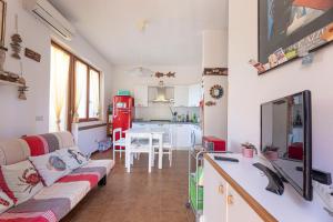 a living room with a couch and a kitchen at Casa Lola - Goelba in Capoliveri