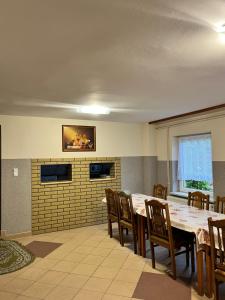 a dining room with a table and wooden chairs at Gospodarstwo Agroturystyczne Na Górce pokój 8 in Myczkowce