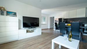 a kitchen and living room with a tv and a table at Black Forest Apartment in Friesenheim