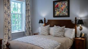 a bedroom with a bed and two windows at Grafton Village Inn in Grafton