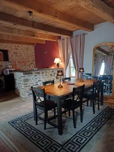 una sala da pranzo con tavolo e sedie in legno di La petite Salamandre bleue a La Croisille-sur-Briance