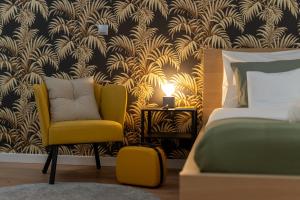 a bedroom with a yellow chair next to a bed at Old Town Luxe Retreat - King Bed - Steps to Main Square in Kraków
