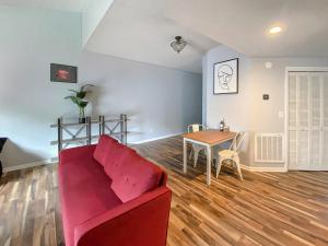 ein Wohnzimmer mit einem roten Sofa und einem Tisch in der Unterkunft Corporate Suite Midtown Wilmington in Wilmington