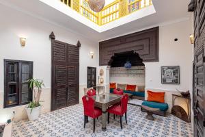 a living room with a table and red chairs at Riad GUENAOUA Jacuzzi & Rooftop in Marrakesh