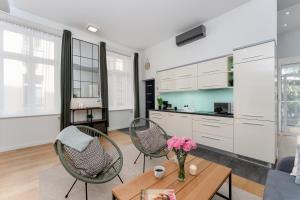 a kitchen and living room with a table and chairs at Old Town Luxe Retreat - King Bed - Steps to Main Square in Kraków