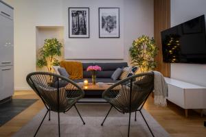 a living room with a couch and a table and chairs at Old Town Luxe Retreat - King Bed - Steps to Main Square in Kraków