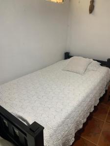 a bed in a bedroom with a white mattress at Un Café en el camino Guest House in Salento