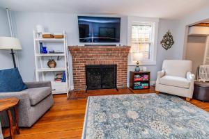 a living room with a fireplace and a tv at Historic Downtown Annapolis Gem Near USNA in Annapolis