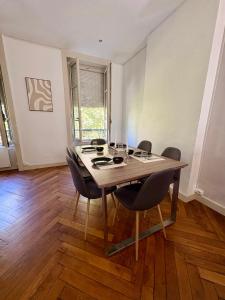 Un comedor con mesa y sillas en Le Brottaux, en Lyon 7 fotos más