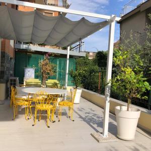 patio con tavolo e sedie sotto ombrellone di Santorini in Finale a Finale Ligure