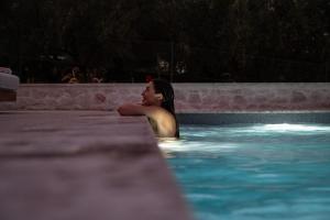 a woman is laying in a swimming pool at Villa Orama in Argos