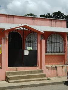 科万Cobán room的粉红色的建筑,设有门和楼梯 更多14张照片
